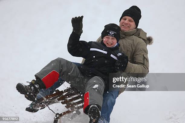 Rafael Moschner and his nephew Tobias Moschner catch air as they sled down a hill in Zehlendorf district on January 10, 2010 in Berlin, Germany. A...