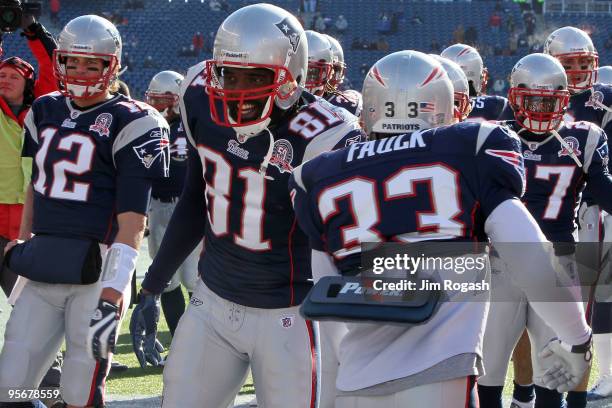 Tom Brady and Randy Moss of the New England Patriots greet their teammates on the field during warm ups against the Baltimore Ravens during the 2010...