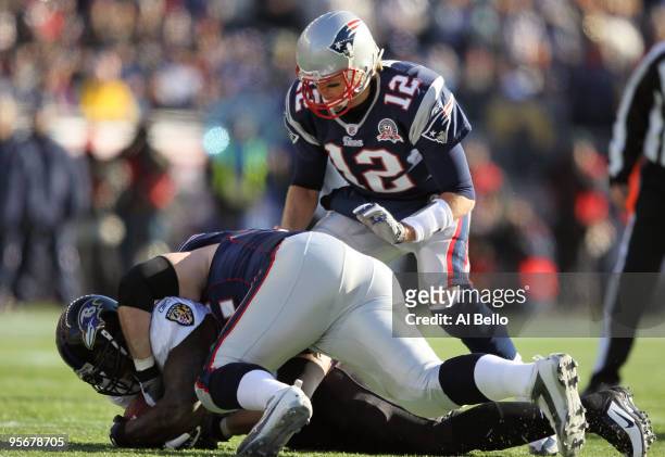 Terrell Suggs of the Baltimore Ravens recovers a fumble that he striped from Tom Brady of the New England Patriots during the first quarter of the...
