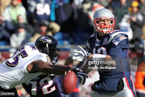 Terrell Suggs of the Baltimore Ravens stripes the ball from Tom Brady of the New England Patriots during the first quarter of the 2010 AFC wild-card...
