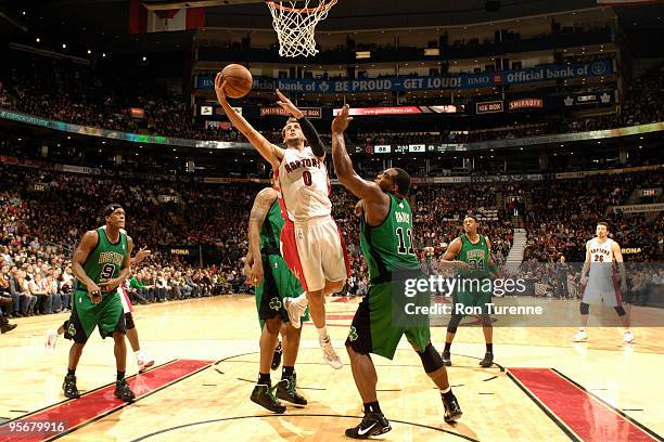 Marco Belinelli of the Toronto Raptors attempts the layup in the paint contested by Glen Davis of the Boston Celtics during a game on January 10,...