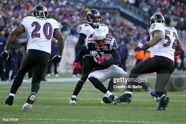Randy Moss of the New England Patriots attempts to run for yards after the catch against Ed Reed, Dominique Foxworthy and Ray Lewis of the Baltimore...