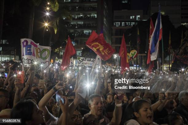 Supporters of Gustavo Petro, presidential candidate for the Progressivists Movement Party, hold up illuminated smartphones and flags during a...