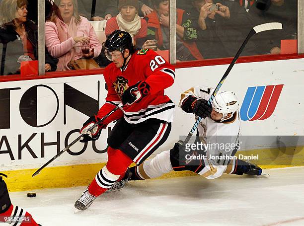 Jack Skille of the Chicago Blackhawks controls the puck as Petteri Nokelainen of the Anaheim Ducks falls against the boards at the United Center on...