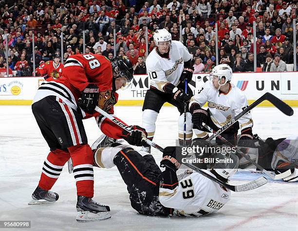 Patrick Kane of the Chicago Blackhawks tries to get at the puck as Matt Beleskey of the Anaheim Ducks lays on the ice and Corey Perry of the Ducks...