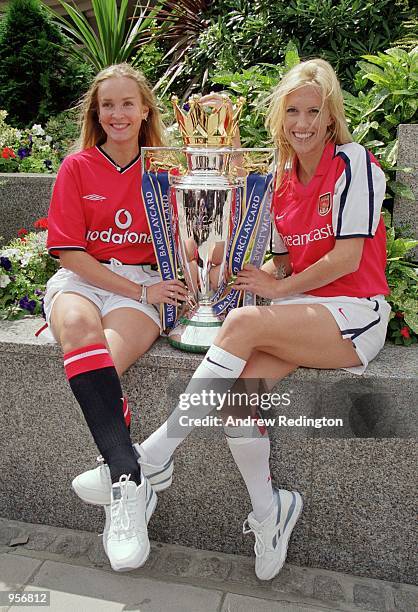 Models dressed up in Manchester United and Arsenal team colours pose with the Premier League title to help promote the launch of the new FA...