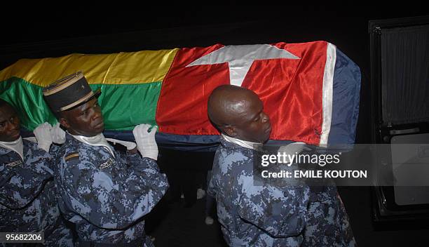 Togolese gendarmes carry the coffin wrapped in the national flag of one of the victims of the Forces for the Liberation of the State of...