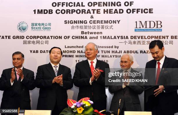 Malaysian Prime Minister Najib Razak claps with Liu Zhenya , State Grid Corporation of China president, Abdul Taib Mahmud , Chief Minister of Sarawak...