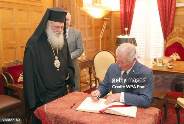 Prince Charles, The Prince of Wales signs a visitors book watched by His Beatitude Archbishop Ieronymos II of Athens and All Greece during a visit to...