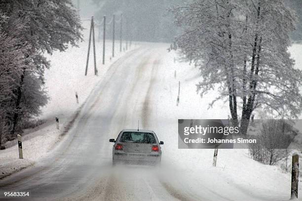 Car makes its way along a snow covered street on January 11, 2010 Diessen am Ammersee, Germany. Depression 'Daisy' brought havoc in Germany as...