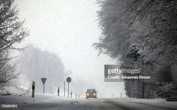 Car makes its way along a snow covered street on January 11, 2010 near Diessen am Ammersee, Germany. Depression 'Daisy' brought havoc in Germany as...
