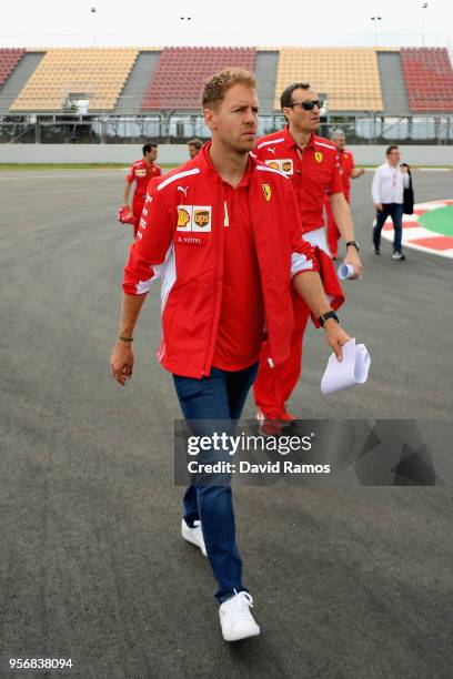 Sebastian Vettel of Germany and Ferrari walks the track with his engineers during previews ahead of the Spanish Formula One Grand Prix at Circuit de...