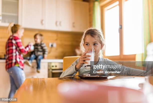 cute little girl drinking milk during breakfast in dining room. - children only stock pictures, royalty-free photos & images