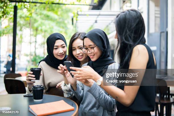 一群多民族的馬來西亞女孩看著智慧手機 - malaysia beautiful girl 個照片及圖片檔