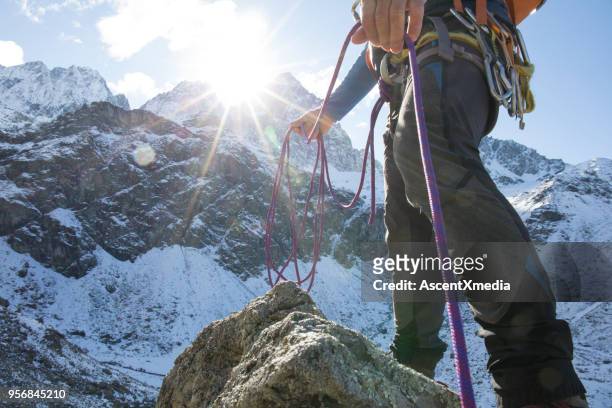 niedrigen winkel ansicht der bergsteiger mit seil in bergen - purple pants stock-fotos und bilder
