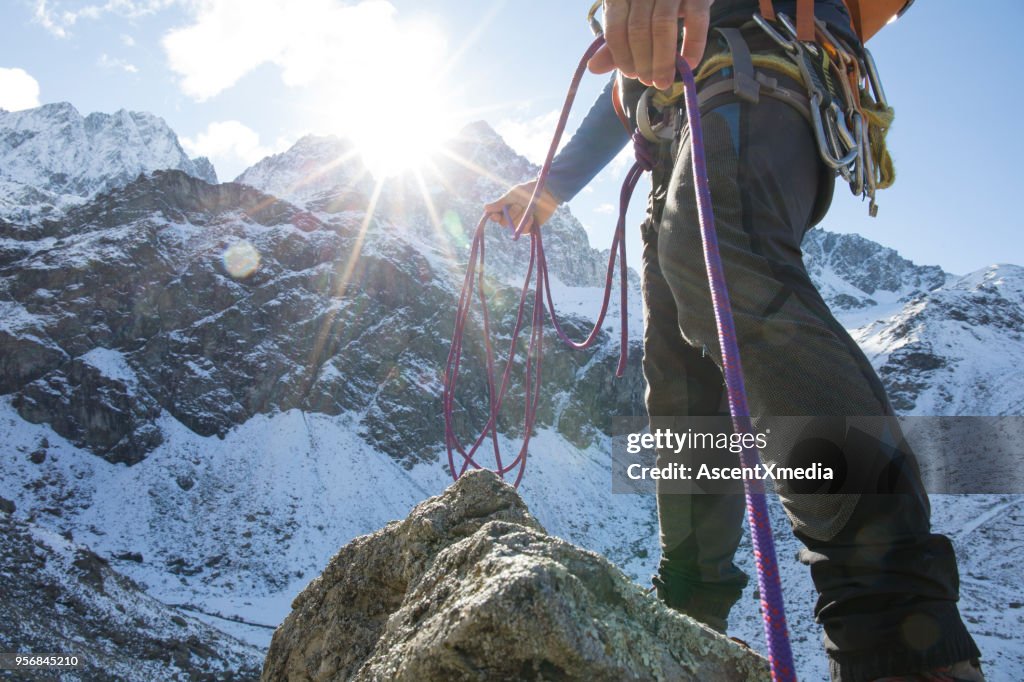 Vista de ângulo baixo de alpinista com corda nas montanhas