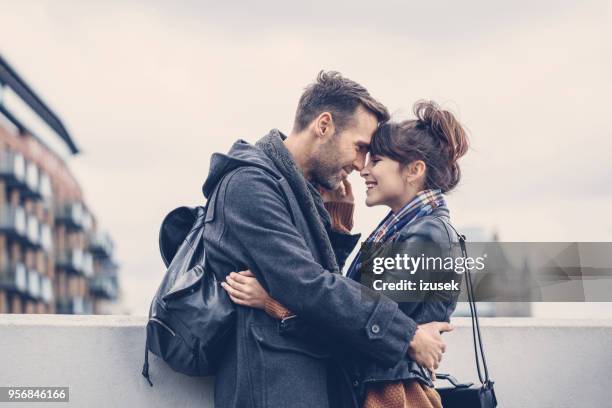 im freien schuss des glücklichen paares flirten auf brücke in london - hugging self stock-fotos und bilder