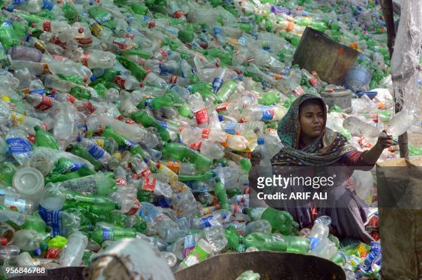 Pakistani worker sorts out plastic bottles at a warehouse in Lahore on May 10, 2018.