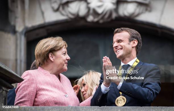 German Chancellor Angela Merkel and French President Emmanuel Macron gesture on the balcony of the town hall of Aachen after Macron recieved the...
