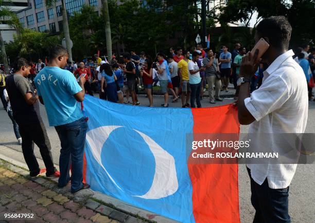 Supporters of the opposition "pakatan harapan" wait outside the Istana Negara where former Malaysian prime minister and opposition candidate Mahathir...