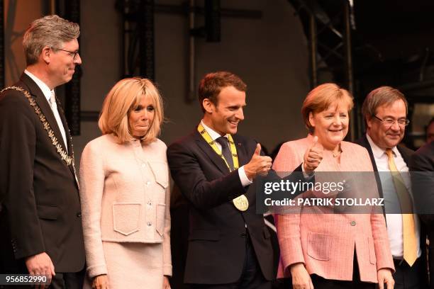 France's President Emmanuel Macron gestures next to Germany's Chancellor Angela Merkel, his wife Brigitte Macron , North Rhine-Westphalia's State...