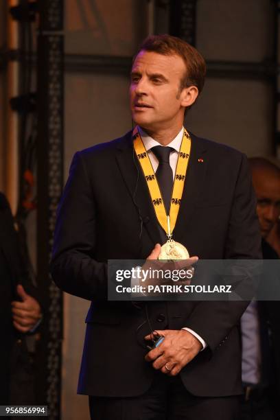France's President Emmanuel Macron talks to Germany's Chancellor Angela Merkel at the end of the Charlemagne prize award ceremony on May 10, 2018 in...