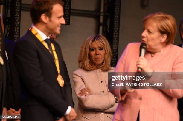 France's President Emmanuel Macron talks to Germany's Chancellor Angela Merkel as his wife Brigitte Macron looks on at the end of the Charlemagne...