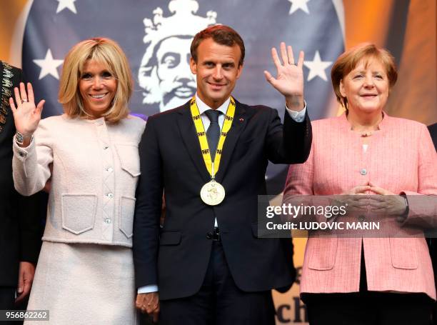 France's President Emmanuel Macron , his wife Brigitte Macron and Germany's Chancellor Angela Merkel wave at the end of the Charlemagne prize award...