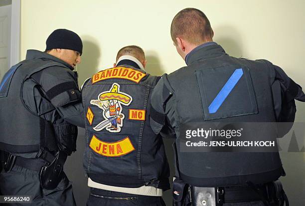 Member of the motorcycle gang "Bandidos" is searched by police as he arrives for the trial of 6 of the gang's members in the eastern German city of...