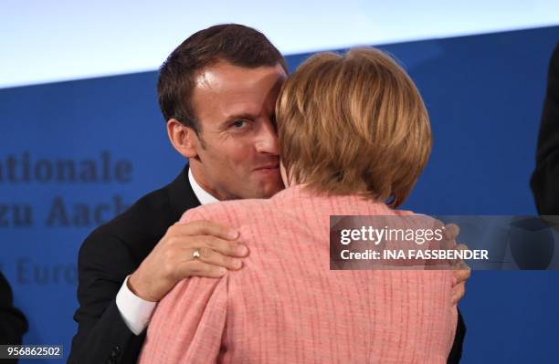 France's President Emmanuel Macron is congratulated by German Chancellor Angela Merkel after receiving the Charlemagne prize award during the award...