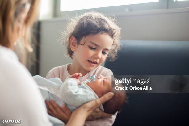 family visiting after a childbirth - young sister stock pictures, royalty-free photos & images