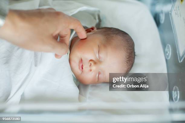 niño bebé recién nacido en el cuna de hospital despierto - premature baby incubator fotografías e imágenes de stock