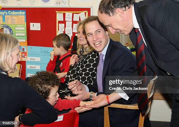 Prince William and his private secretary Jamie Lowther-Pinkerton meet children at Eresby School on January 11, 2010 in Spilsby, England. The Prince...