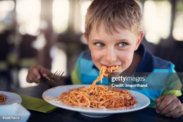 cute little boy eating spaghetti - the joys of eating spaghetti stock pictures, royalty-free photos & images