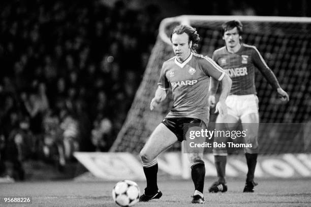 Manchester United's Arthur Graham on the ball watched by Ipswich Town's Kevin Steggles during their Division One football match held at Portman Road,...