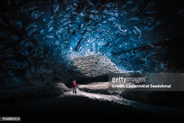 a man in the crystal ice-cave, iceland - crystal caves stock-fotos und bilder