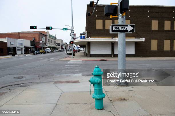 fire hydrant and one way sign at street of beatrice, nebraska, usa - hydrant stock-fotos und bilder