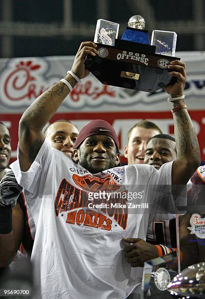 Tailback Ryan Williams of the Virginia Tech Hokies raises the Most Outstanding Offensive Player trophy after the Chick-fil-A Bowl against the...