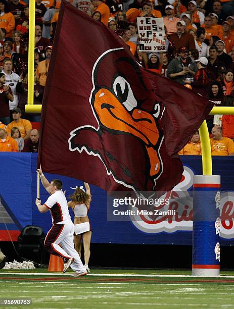 Virginia Tech Hokies cheerleader runs in the end zone with a flag after a Virginia Tech touchdown during the Chick-Fil-A Bowl during the Chick-Fil-A...