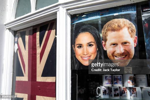 Masks of Prince Harry and his fiance US actress Meghan Markle sit in the window of a gift shop on May 10, 2018 in Windsor, England. St George's...