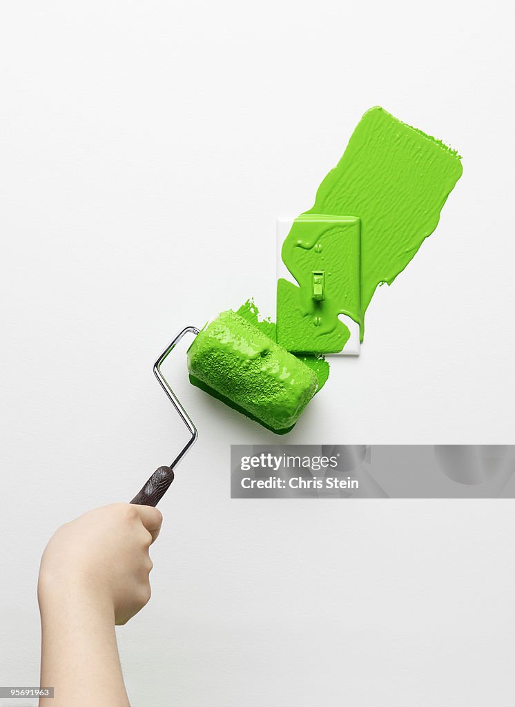 Woman painting a light switch