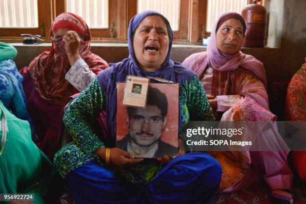 Sister of Mohammad Ramzan Sheikh holds the picture of her brother at the commemoration of her Mother Rehti Begum, an active member of APDP, who...