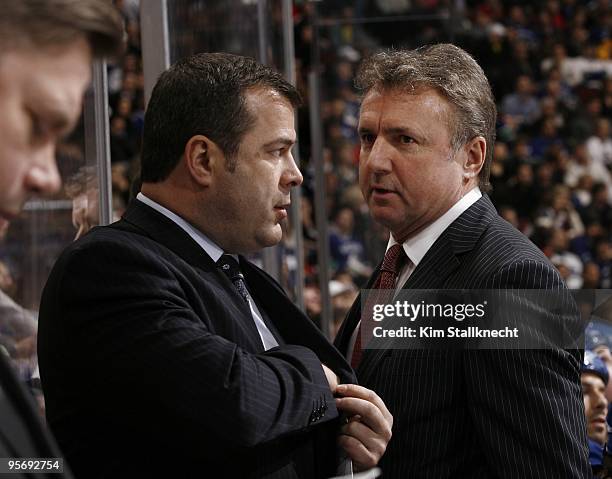 Vancouver Canucks head coach Alain Vigneault confers with Associate Coach Rick Bowness before the shoot out against the Calgary Flames during NHL...