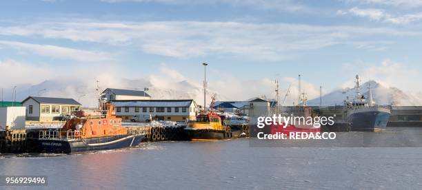 The frozen harbour of the small town Hoefn during winter. In the background the mountains of Stokksnes. Europe. Northern europe. Iceland. February.