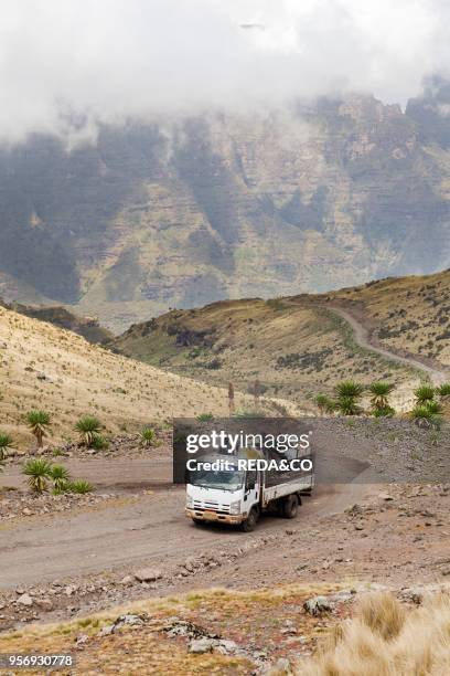 Dirt road with truck winding through the Simien Mountains at Bwahit Pass app.4000m. Africa. East Africa. Ethiopia.