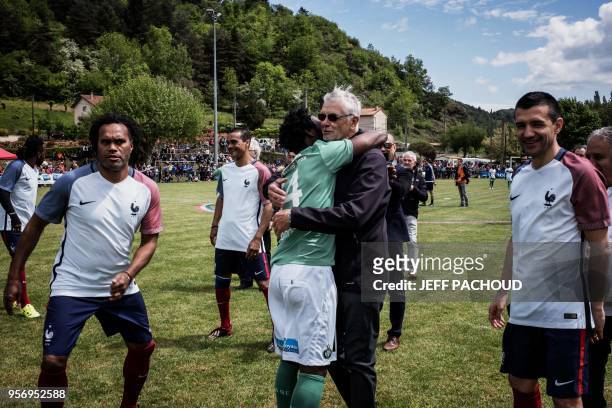 Aime Jacquet , former coach of French national football team hugs a player on the pitch before a football match between former French Team members...