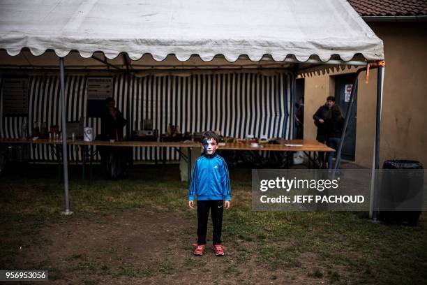 Boy with his face painted in French national colors poses, on May 10, 2018 in Sail-sous-Couzan, western France, on the day the French national...