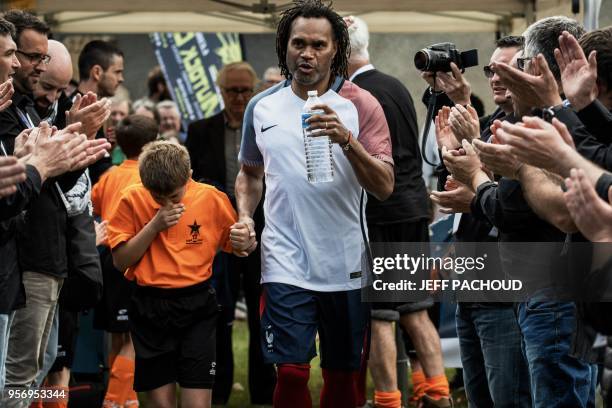 Former French national football team player Christian Karembeu enters the pitch before a football match between former French Team members and former...