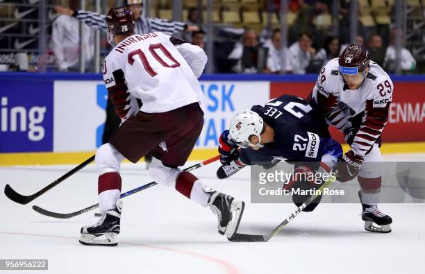 Anders Lee of United States and Ralfs Freibergs of Latvia battle for the puck during the 2018 IIHF Ice Hockey World Championship Group B game between...
