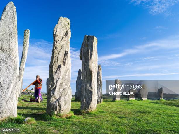 Standing Stones of Callanish on the Isle of Lewis in the Outer Hebrides. Summer solstice being celebrated by gaudy people. The megalithic monument is...